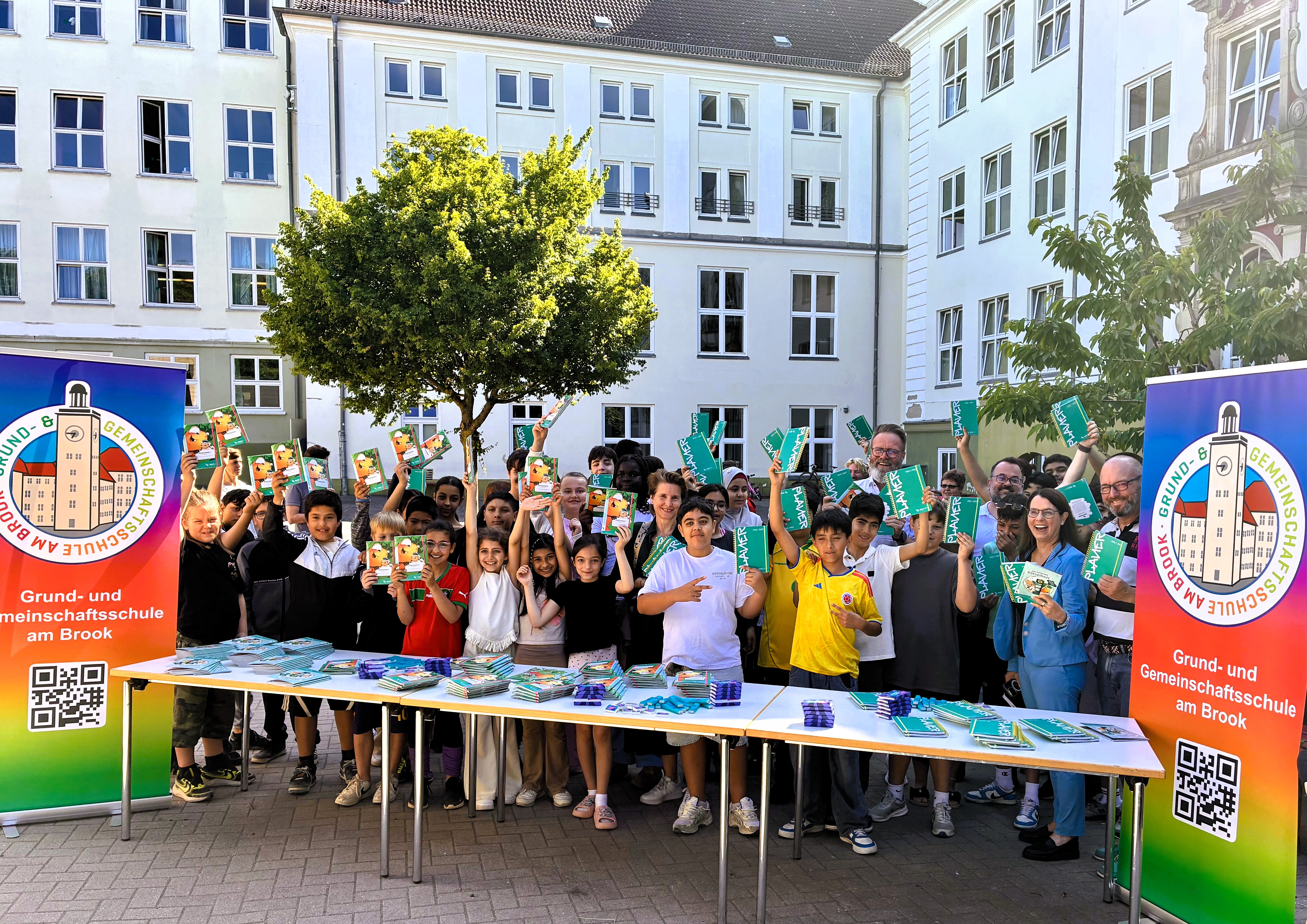 Eine Gruppe von Kindern hält begeistert die Planer und Möhrchenhefte in die Kamera